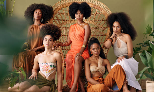 Black women surrounding a large wicker chair indicative of a throne